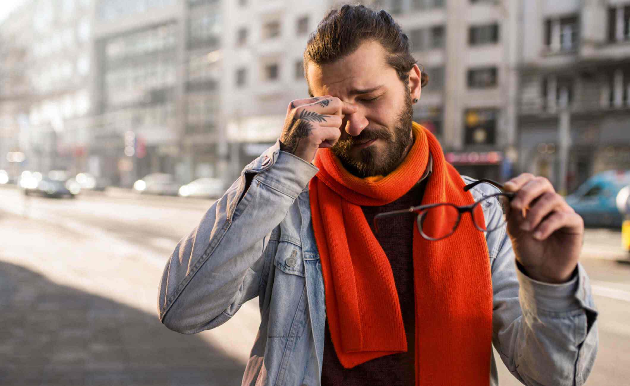 Man pinching nose holding glasses in red scarf, header image for Hindsight blog