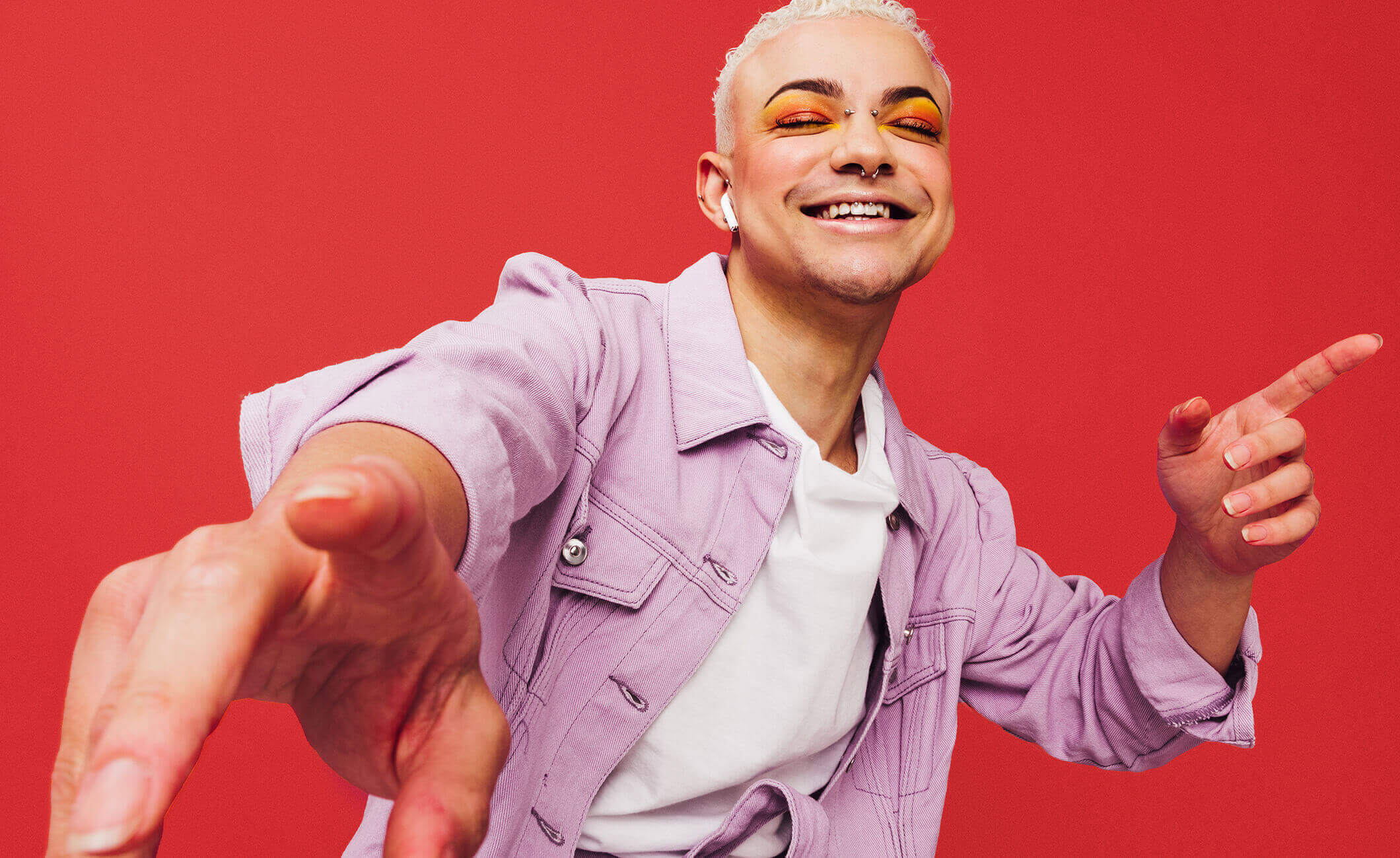 person smiling and dancing with a red background