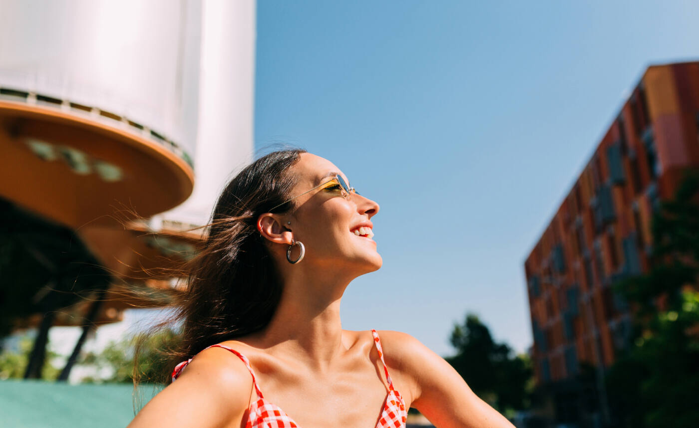 girl smiling in the sun, how to live luxe for less